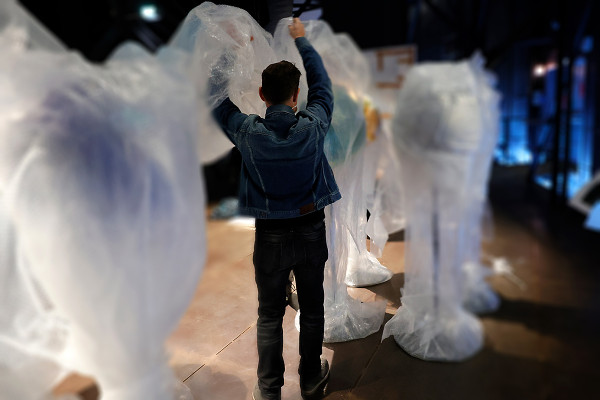 Ein Mitarbeiter kämpft mit der Verpackungsfolie der Globen.