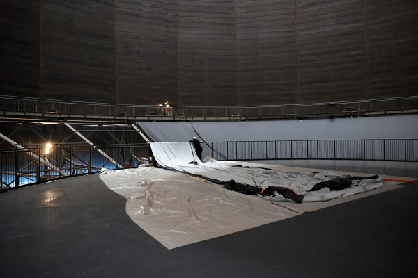 Ein Arbeiter legt die Stoffbahnen für die Abdunkelung auf der Manege aus.