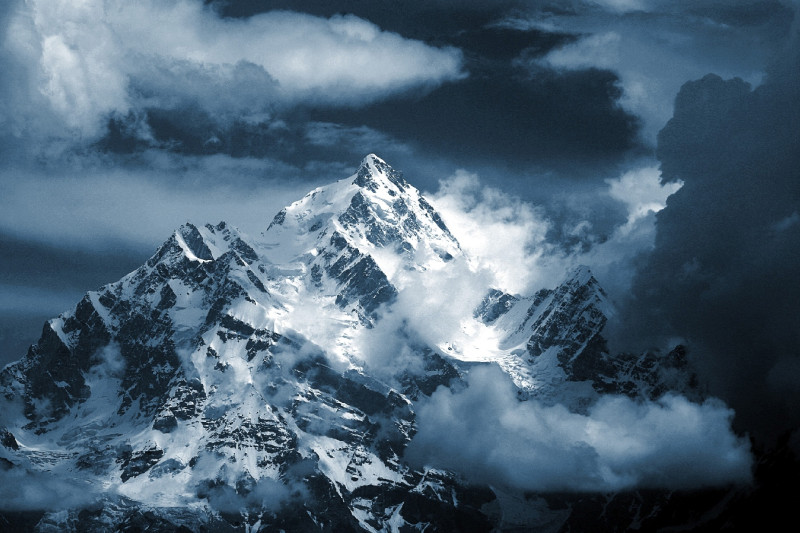 Blick auf ein Bergmassiv mit Wolken und Sonnenschein