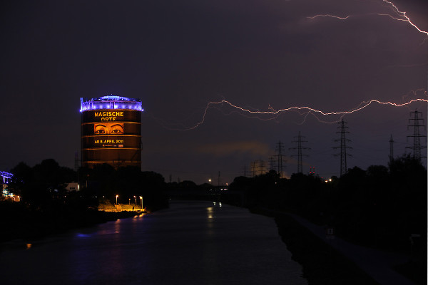 Landschaftsaufnahme des Gasometers bei Gewitter mit Blitzen