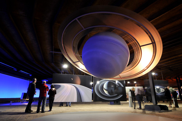 Besucher betrachrten Planetenskulpturen und großformatige Bilder