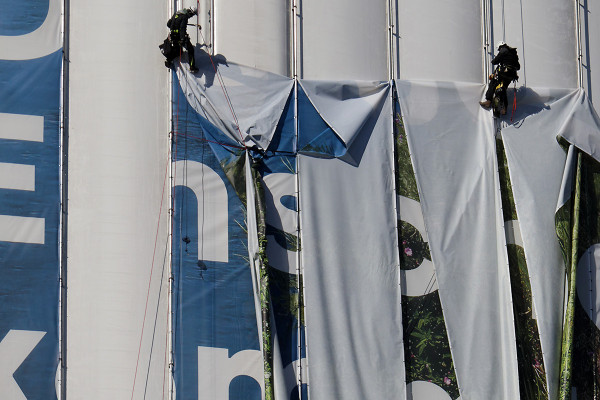 Zwei Industiekletterern nehmen das Megaposter der Emschergenossenschaft am Gasometer Oberhausen ab