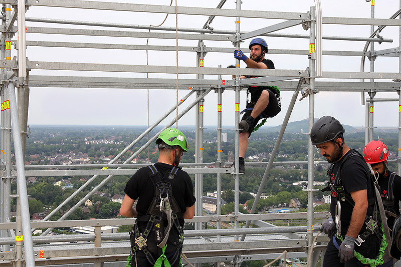 Vier Gerüstbauer auf der Dachkontruktion des Gasometers