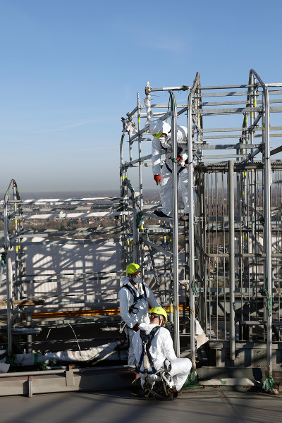 Drei Gerüstbauer auf dem Dach des Gasometers