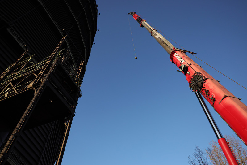 Ein Kranausleger mit dem Gasometer im Hintergrund, fotografiert aus der Froschperspektive.