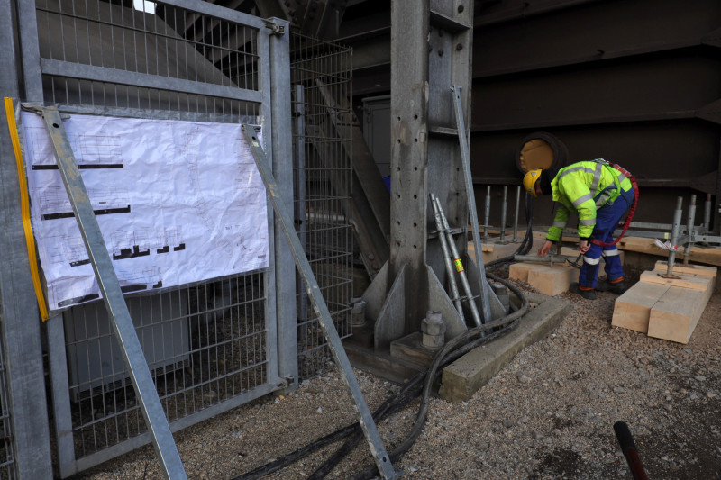 Ein Gerüstbauer beginnt mit dem Aufbau der ersten Gerüststützen.