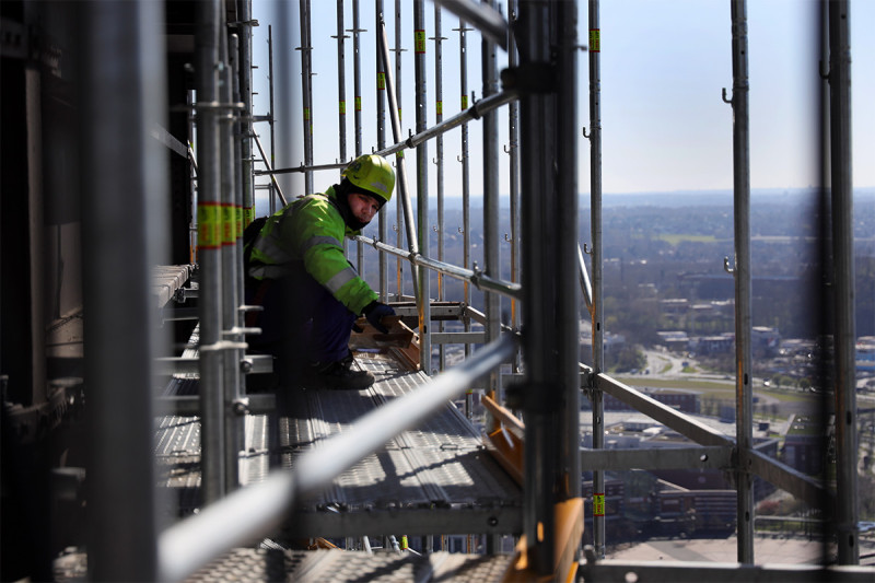 Ein Gerüstbauer arbeit in großer Höhe.