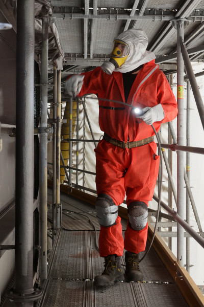 Arbeiter in Vollmontur bei der Aufbringung der finalen Deckschicht an der Gasometer Außenhüllee