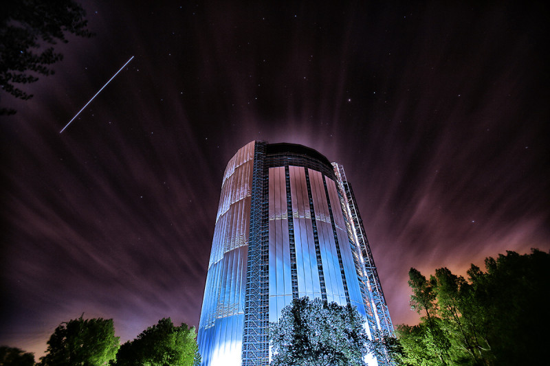 Gasometer bei Nacht mit vorbeiziehender ISS als Lichtstreifen